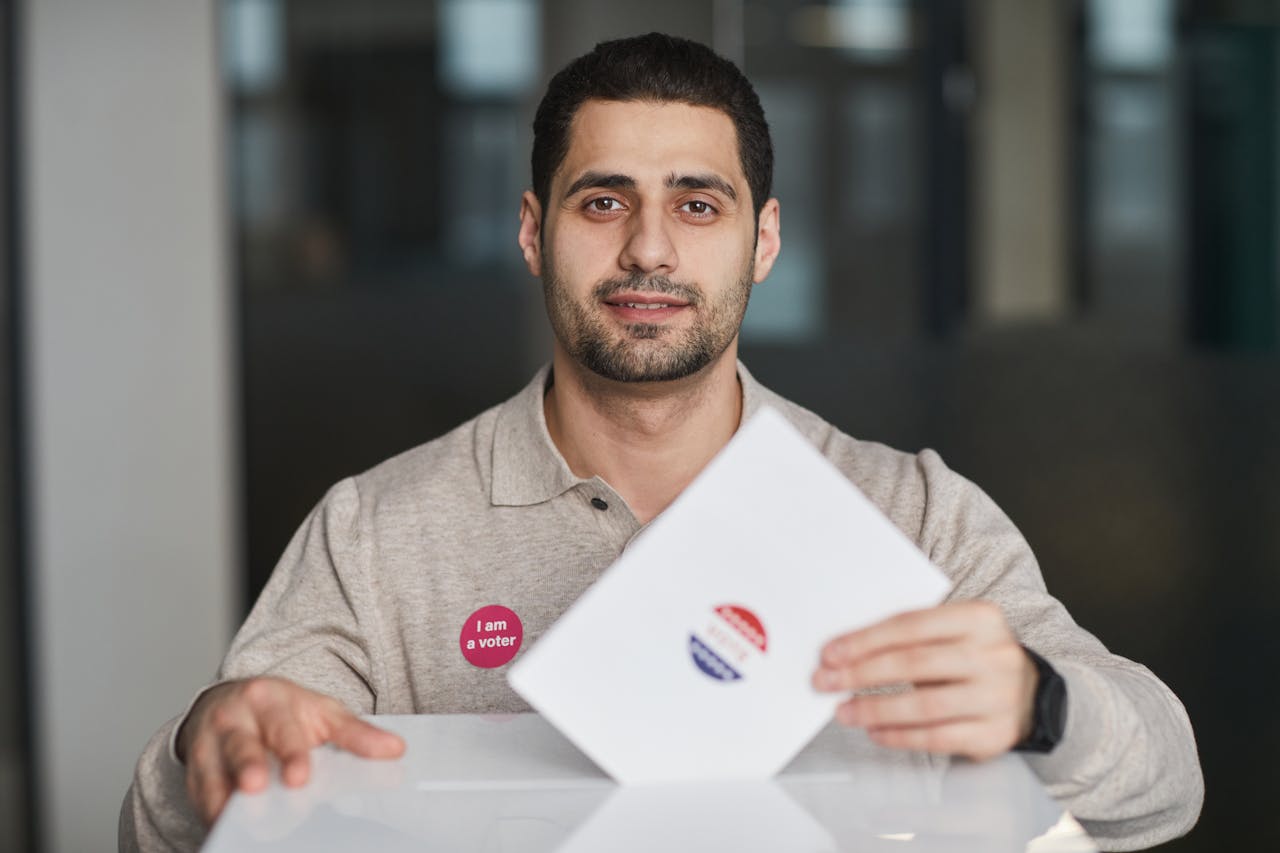 A man with a I am a voter sticker casting his ballot on election day.